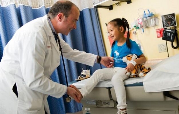 a doctor examines a child with hip osteoarthritis