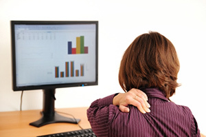 Cervical osteochondrosis in a woman sitting in front of a computer